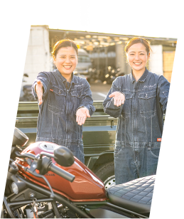バイクの前で両手を前に出す女性スタッフ2人の写真